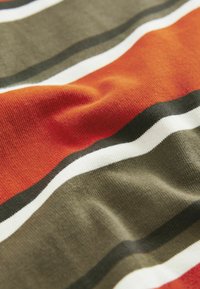 Striped fabric featuring alternating bands of orange, olive green, white, and dark green, with a soft texture and slight wrinkling.
