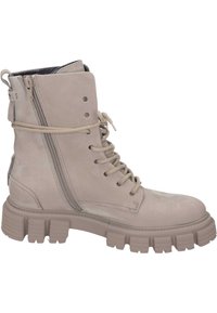 Bottines beige clair en suède avec une semelle épaisse, lacées à l'avant et dotées d'une fermeture éclair sur le côté. Présente des coutures visibles et une finition mate.