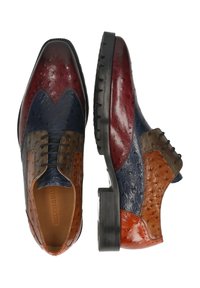 Zapatos brogue de cuero para hombre en rojo, azul, marrón y naranja con un patrón texturizado y suelas de goma negra, vista superior de un zapato y vista lateral de otro.
