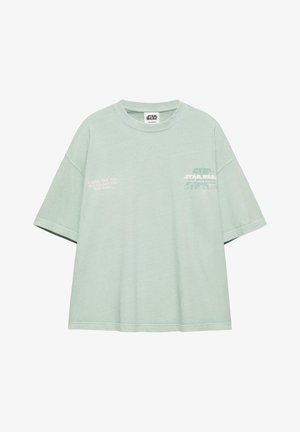 Vaaleanvihreä Star Wars -t-paita lyhyillä hihoilla, pyöreällä kaula-aukollla ja valkoisella painatuksella rinnassa ja vasemmalla puolella.