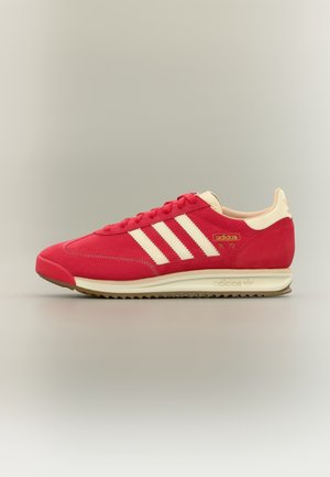 Rode Adidas SL 72 sneaker met witte strepen, beige accenten en een gestructureerde beige zool op een effen lichtgrijze achtergrond.