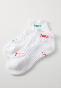 Fehér bokazokni, zöld és piros "PUMA" logókkal. Piros részletekkel és bordázott mandzsettával a textúra fokozása érdekében.