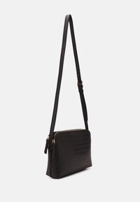 Borsa a tracolla in pelle nera con effetto coccodrillo, di forma rettangolare piatta, con zip di colore oro e tracolla regolabile. Texture liscia.