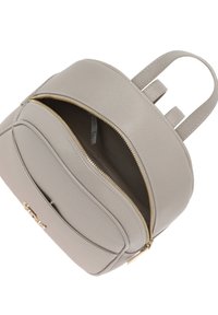 Zaino in pelle beige con una texture liscia, doppie cerniere, tasca frontale e spallacci regolabili. Interno spazioso e foderato.