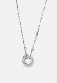 Collier chaîne en argent avec pendentif circulaire gravé "GUESS" et orné de petits cristaux clairs, accompagné d'un petit pendentif "GUESS" sur la chaîne.