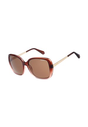 Übergroße quadratische Sonnenbrille mit braun getönten Gläsern, transparentem braunem Kunststoffrahmen und dünnen goldfarbenen Metallbügeln mit schwarzen Enden.