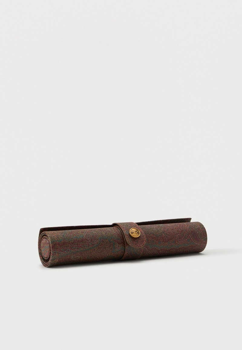 Étui en cuir brun à motif cachemire roulé, sécurisé par une sangle et une fermeture à bouton doré sur fond blanc uni.