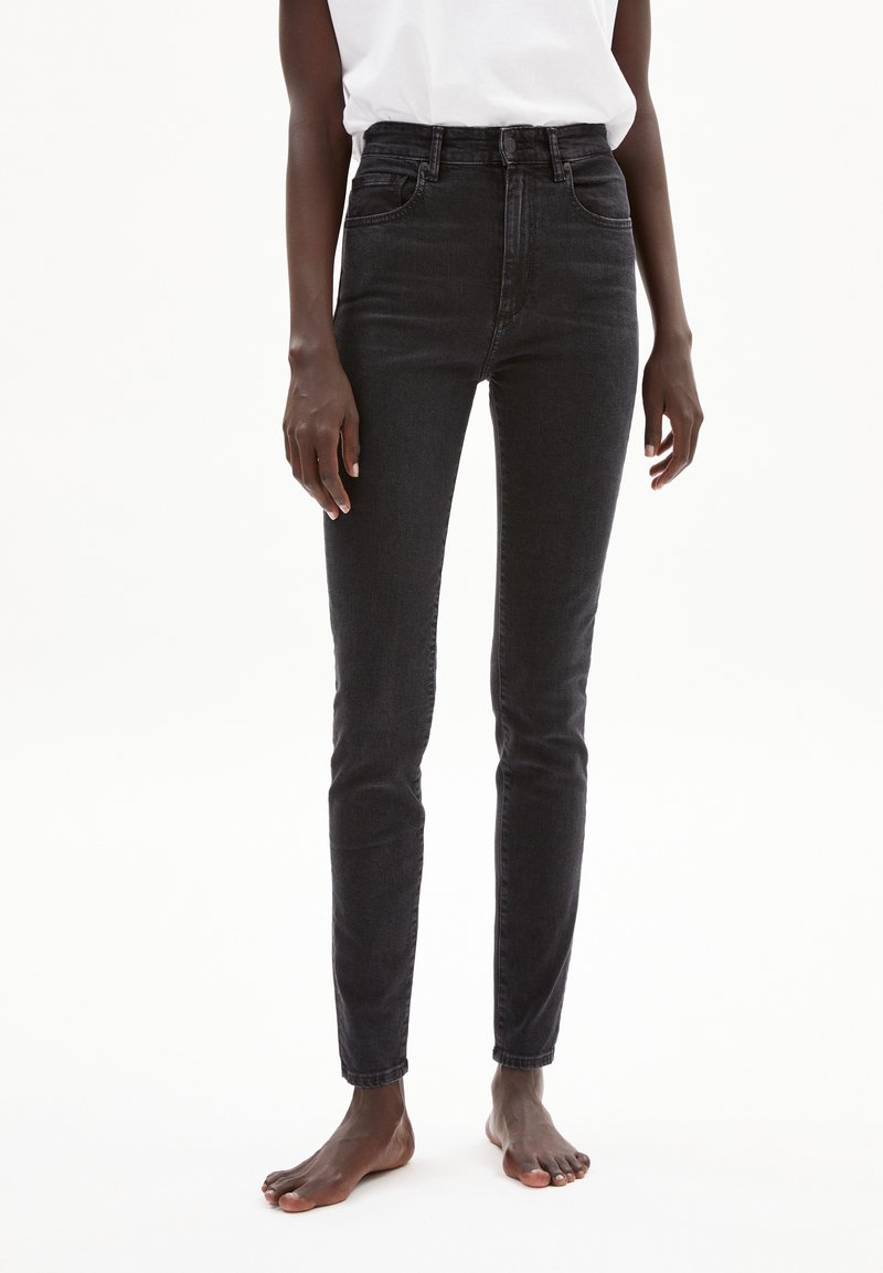 Jean skinny noirs taille haute en denim, dotés d'un design classique à cinq poches et de détails de couture subtils.