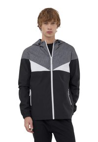 Giacca a vento nera e grigia con cappuccio, caratterizzata da un design geometrico bianco sul petto e tasche con zip. Leggera, con una texture liscia.