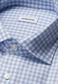 Camicia a quadri blu e bianchi con colletto classico, bottoni in plastica e un'etichetta con la scritta "seidensticker" all'interno.