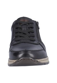 Sneaker in pelle nera con punta tonda, design con lacci, cerniera laterale, suola testurizzata e dettagli beige sulla suola esterna.