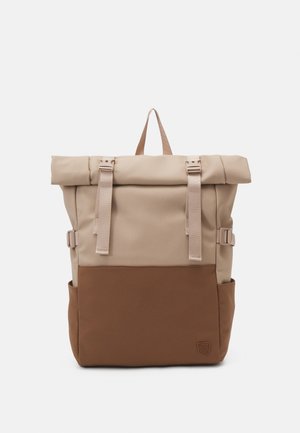 Roll-top backpack in beige nylon with a brown bottom panel, featuring adjustable straps, a top handle, and side pockets for storage.