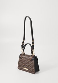 Borsa a mano con motivo marrone e nero, dalla forma strutturata, con hardware dorato e una tracolla removibile. Presenta una maniglia superiore e un design geometrico.