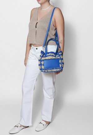 Borsa blu e beige con un design testurizzato e intrecciato e accentuazioni in pelle liscia. Caratterizzata da doppie maniglie e una tracolla rimovibile.