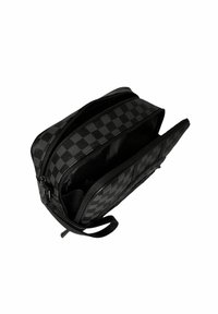 Bolsa de tela a cuadros negros con dobles cremalleras, forma plana, textura suave y un asa lateral para facilitar el transporte. El interior es espacioso.