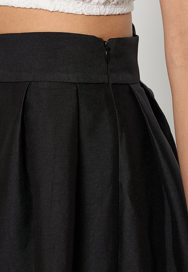 Czarna plisowana spódnica o gładkiej fakturze, z ukrytym zapięciem na zamek i szerokim pasem w talii, zapewniająca dobrze dopasowany krój.