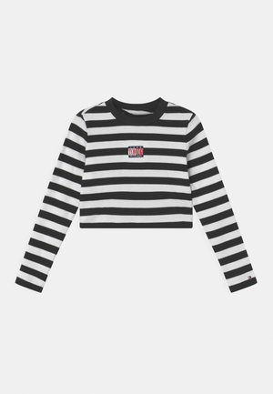 Black and white horizontal striped long-sleeve crop top with "Tommy Hilfiger" logo patch on chest and small logo on left sleeve cuff.