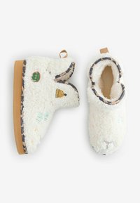 Pehmed valged sussid, millel on kohev tekstuur, beež tall, värvikirevate tikandmustritega, leopardimustrilise äärise ja tõmbasilmusega.