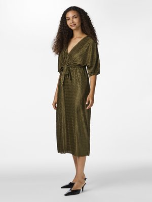 Green pleated wrap dress with a deep V-neck and tie waist. Features short sleeves and a mid-calf length. Worn with black pointed shoes.