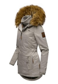 Giacca grigia chiara con un grande cappuccio in pelliccia marrone, chiusura con zip, due tasche laterali e un patch con logo sulla manica. Presenta polsini a costine.