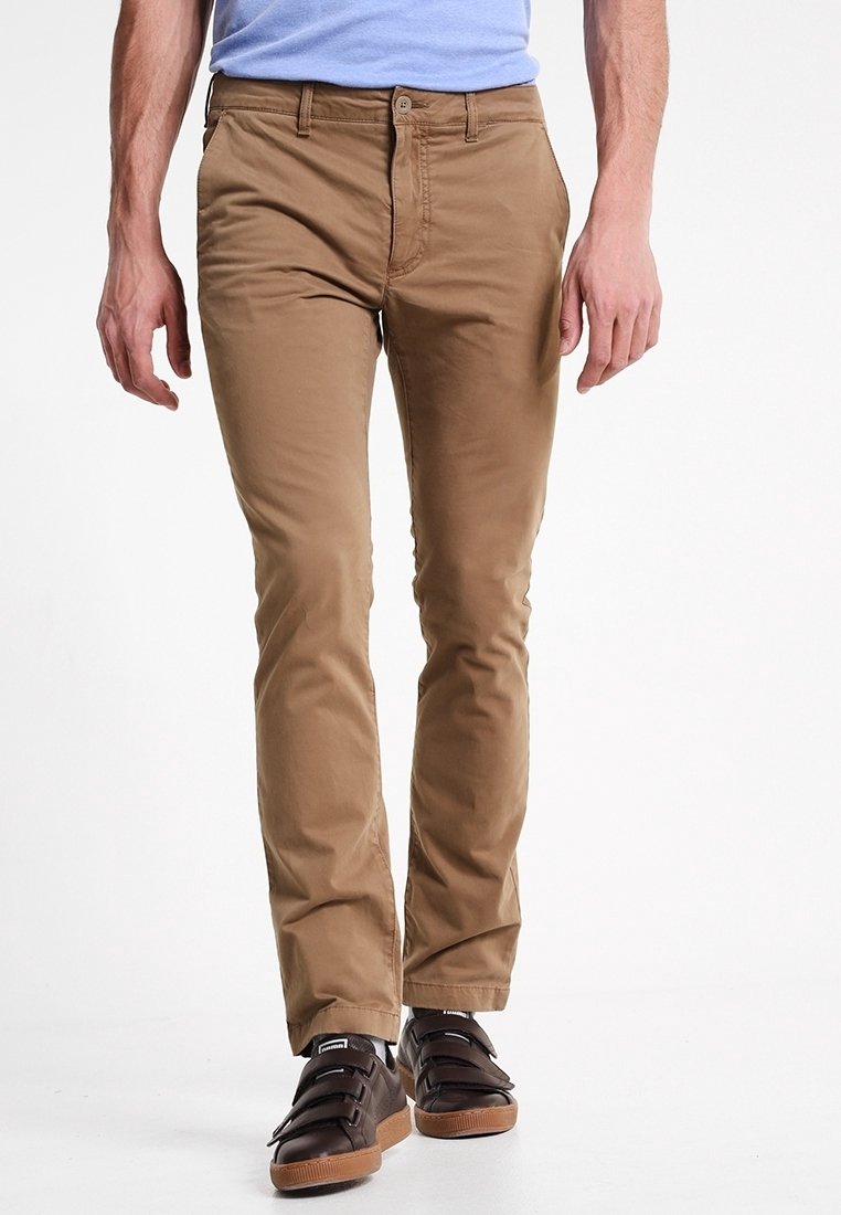 Chino beige con una vestibilità slim, realizzati in cotone, con una parte frontale piatta, tasche laterali e una texture liscia. Abbinati a scarpe con strappo marrone scuro.