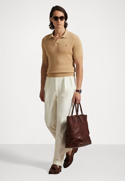 Μπεζ ριγωτό πόλο κοντομάνικο, κρεμ πλισέ παντελόνι, καφέ δερμάτινη τσάντα, καφέ μοκασίνια και σκούρα γυαλιά ηλίου.