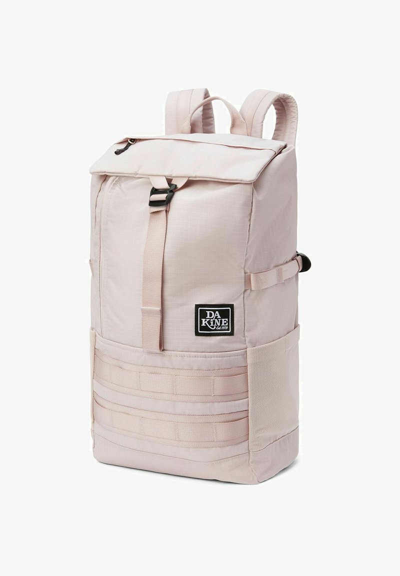 Sac à dos rose clair en tissu durable. Présente un rabat supérieur, une boucle à déverrouillage rapide, un logo en patch à l'avant, et un tissage latéral pour fixation.