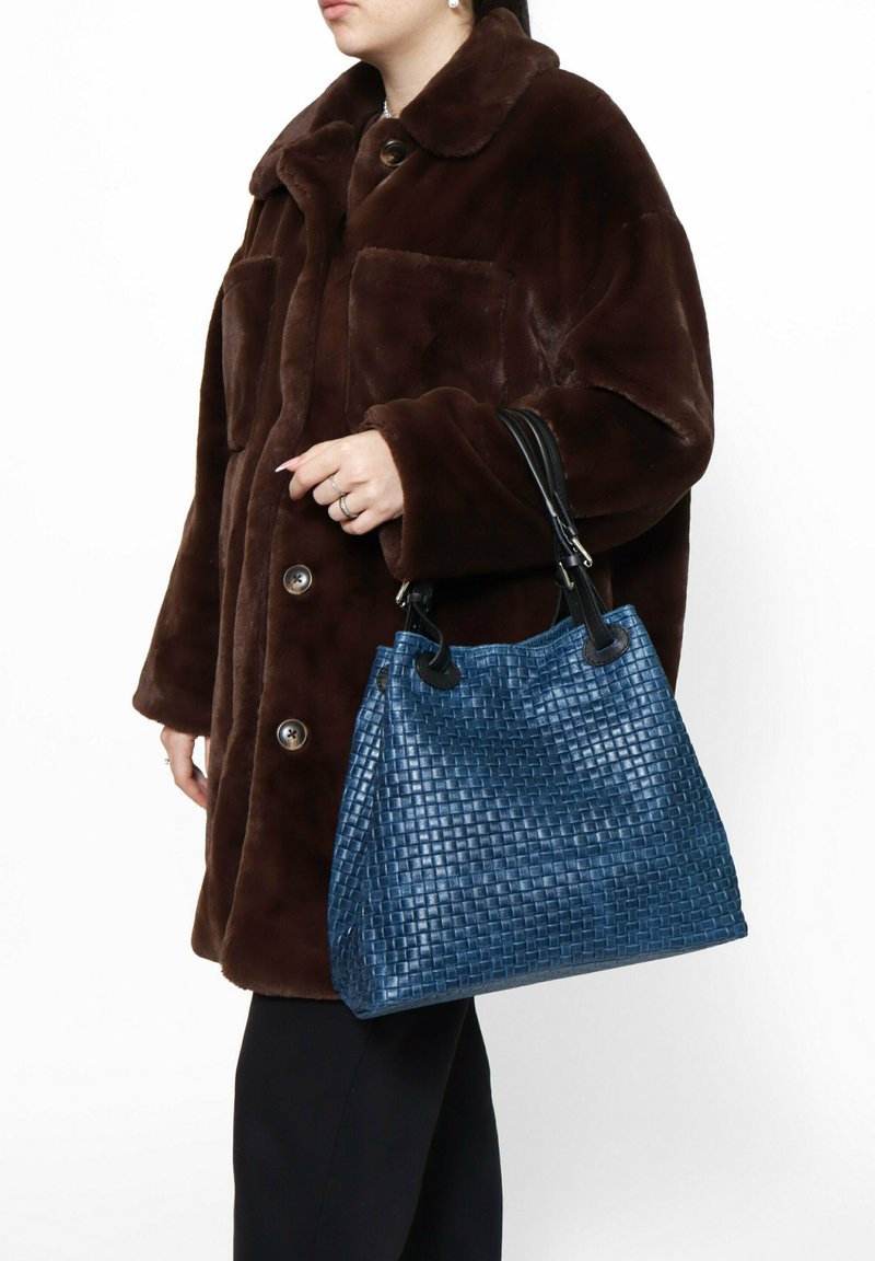 Borsa a tracolla in pelle blu intrecciata con manici neri, forma rettangolare, design strutturato, superficie testurizzata e sottile lucentezza.