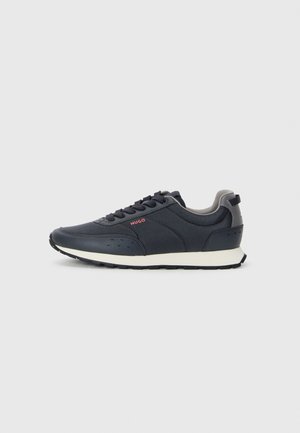 Marinblå sneakers med en slät syntetisk ovandel, rund tå, grå detaljer, snörningsdesign och en vit mellansula med en texturerad svart yttersula.