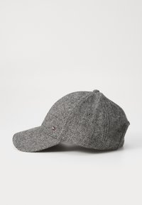 Gray herringbone cap made of wool blend with a curved brim. Features ventilation holes and a small logo accent on the side.