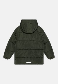Mörkgrön puffjacka med huva, med en kviltad design, långa ärmar och en vit etikett vid bakre fållen. Slät textur.