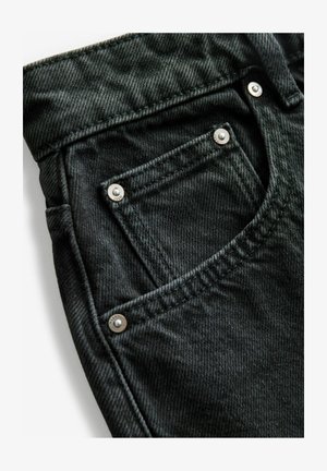 Sötétszürke farmeranyag, ezüst fém hardverrel ellátott zsebbel és részletes varrással. Az anyag textúrált felületű és struktúrált formájú.