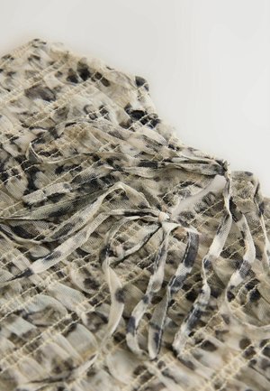 Bluza ușoară din material transparent, bej, cu modele abstracte negre. Are șnururi la decolteu și un design texturat în grilă pe toată suprafața.