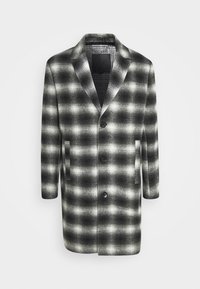 Cappotto a scacchi in bianco e nero con maniche lunghe, colletto a punte, due tasche frontali e chiusura a bottoni, realizzato in tessuto testurizzato.