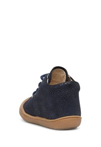 Navy blue suede shoe with perforated texture, rounded back, tan rubber sole, and blue laces. Displays a casual design suitable for children.