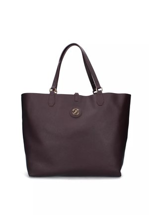 Borsa tote in pelle marrone scuro con due manici e un piccolo emblema circolare dorato al centro anteriore.