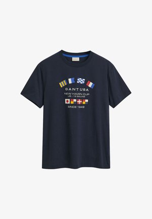 Tumed sinine puuvilla T-särk, millel on ümmargune kaelus ja lühikesed varrukad. Eesmine kujundus sisaldab erinevaid riigilippe ja teksti "GANT USA".