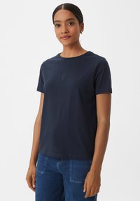 Marineblaue Baumwoll-T-Shirt mit klassischem Rundhalsausschnitt und kurzen Ärmeln. Dezenetes, erhabenes Logo-Detail auf der Vorderseite, glatte Textur.