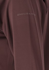 Bordeaux sportshirt van een gladde, lichte stof. Bevat het "ENDURANCE" logo in een contrasterende kleur op de mouw.