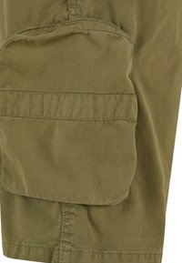 Shorts de marfă verzi, confecționați dintr-un material durabil, având o buzunare mare cu clapetă pe lateral și o textură netedă. Detaliu de tiv cusut vizibil.