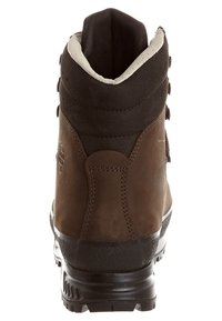 Καφέ δερμάτινη μπότα πεζοπορίας με υφή, μαύρη καουτσούκ σόλα και μεταλλικά μάτια. Διαθέτει επενδυμένο κολάρο και ενισχυμένη πίσω πλευρά.