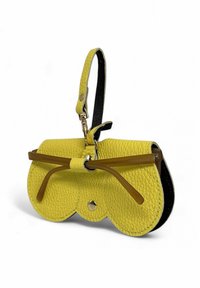 Sac à main en cuir texturé jaune de forme arrondie, avec des accents noirs et un détail de nœud proéminent. Il possède une bandoulière et une fermeture à pression.