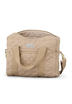 Sac de voyage en tissu matelassé beige avec deux poignées supérieures, poche zippée avant et bandoulière amovible, montrant le compartiment principal ouvert.