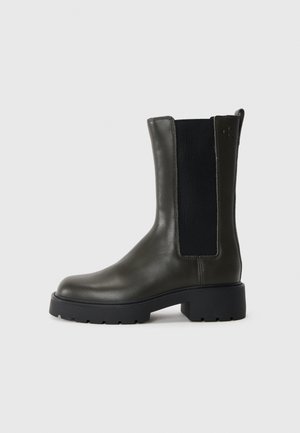 Bota de tornozelo em couro verde com painéis laterais elásticos, ponta arredondada e sola de borracha. Apresenta um acabamento texturizado e um salto bloco.