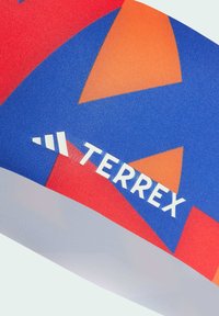 Colorful headband featuring a geometric pattern in red, blue, and orange with white "TERREX" branding and smooth fabric texture.