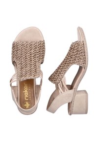 Sandales beiges avec tige en tissu tissé et brides, petit talon carré et semelle intérieure rembourrée. Présente un détail de tressage texturé sur la tige.