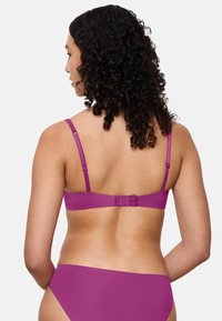 Fuchsia bralette med justerbare tynde stropper, hægte lukning bagpå og glat tekstur. Minimalistisk design med ensfarvet stof.