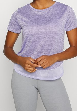 Paarse sportshirt met korte mouwen, gekenmerkt door een gestructureerd patroon, ronde halslijn en mesh-accenten aan de onderzoom. Gepaarde met grijze leggings.