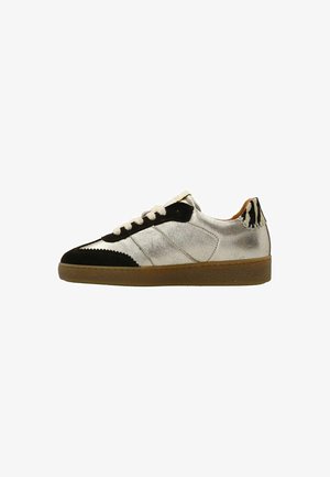 Sneakers met een metallic zilveren bovenwerk, zwarte suède details bij de neus en hiel, beige veters en een gestructureerde bruine rubberen zool.