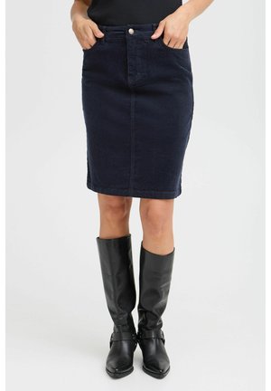 Jupe en denim foncé avec une coupe ajustée, poches avant, et fermeture à un bouton. Associée à des bottes en cuir noir montant jusqu'aux genoux.